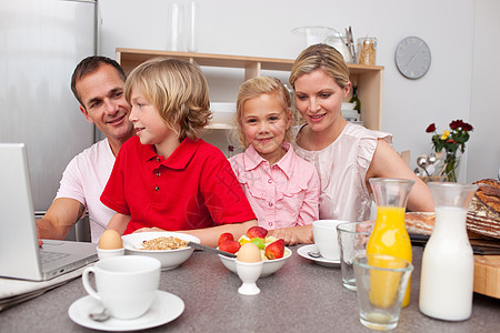 快乐的一家人一起吃早餐男生生长女士水果谷物女孩享受父母孩子们营养图片