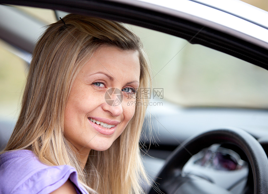 坐在车里的年轻快乐的女司机图片