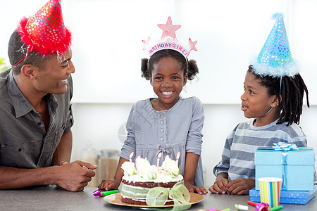 微笑的小女孩和她的全家在庆祝她生日图片
