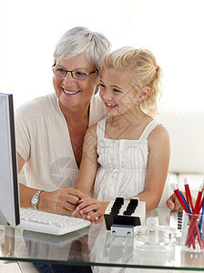 使用计算机的外孙女和祖母图片