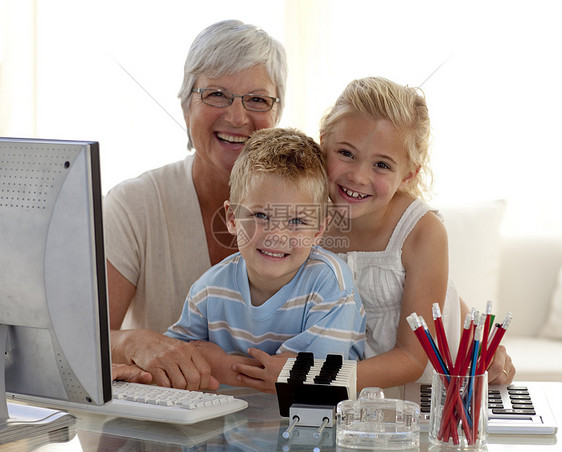 快乐的孩子用电脑和祖母一起使用电脑图片
