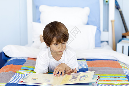 小男孩在床上读书图片