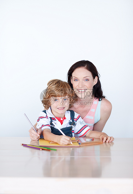 母亲和儿子用复制空间绘制家庭房子家庭作业父母拥抱童年写作安全绘画女士图片