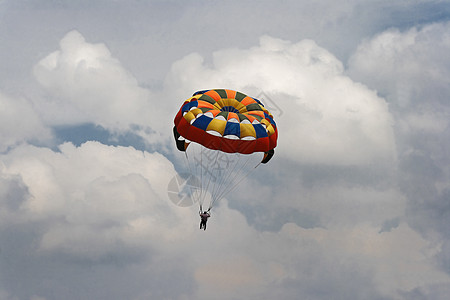 蓝色天空和云层中的男性滑翔伞图片