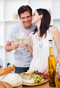 女人亲吻男朋友 用白葡萄酒敬酒图片