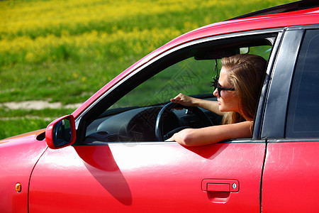 妇女乘坐红色车女孩金发女郎金发车辆运动头发眼睛玻璃快乐成人图片