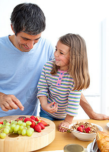 快乐的父亲和女儿一起吃早饭女孩面包桌子维生素谷物父母女性厨房羊角生长图片