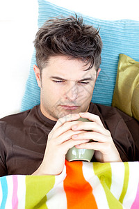 坐在沙发上喝咖啡的压抑的男人会很沮丧图片