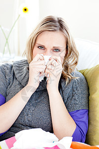 坐在沙发上用纸巾的病妇女保健痛苦女士流感女性症状疾病客厅手帕喷嚏图片