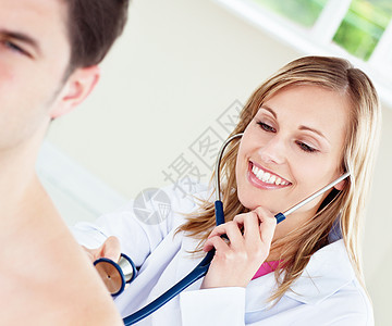 微笑的医生正在检查她的病人背景图片