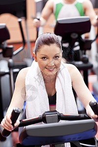 在体育中心使用自行车的体操妇女;图片