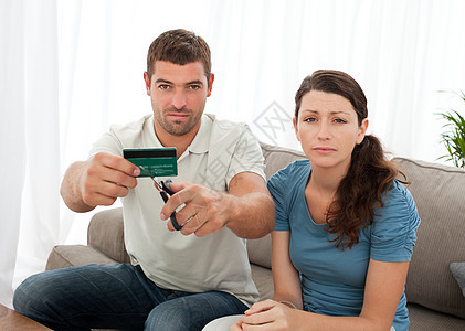 担心的夫妇切开他们的信用卡 一起坐在一起 坐在图片
