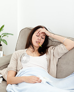 生病的女人在沙发上用温度计取她的温度疾病长椅厌倦客厅药品说谎前额休息组织药片图片