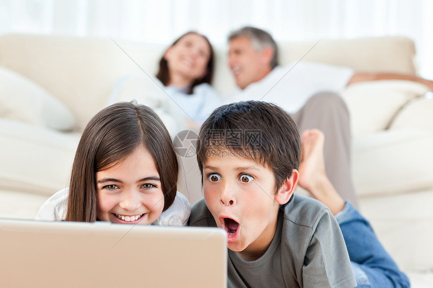 可爱的孩子在家里看笔记本电脑上的电影男人帮助爸爸父亲女士冲浪男性技术办公室互联网图片