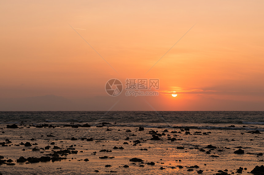 山顶和前线海面上的温暖热带日落海洋天空橙子支撑石头海景天堂金子海岸火山图片