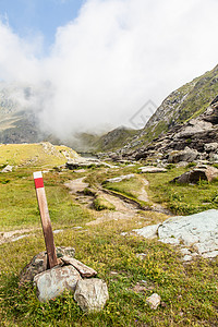 山上的石头意大利阿尔卑斯山上的路径符号旅行岩石小路高度绿色远足天空踪迹顶峰蓝色背景