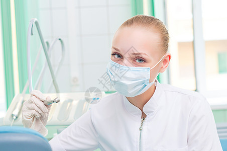 戴保护面罩的女牙医从业者卫生保健援助工人手术外科专家椅子面具图片