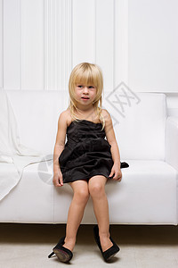 小女孩在试穿大鞋子冒充乐趣成人地面衣服女儿女性沙发孩子模仿图片