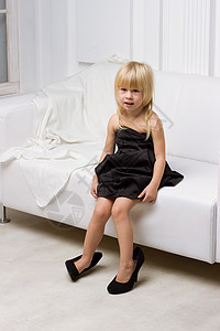 小女孩在试穿大鞋子鞋类喜悦冒充模仿沙发童年孩子高跟鞋衣服快乐图片