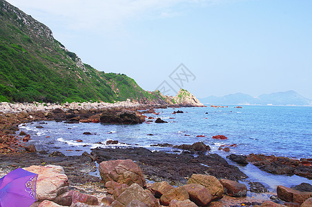 中国的海边有巨大的岩石靛青垂直度海水辉光石头海浪阳光海岸蓝色色调图片