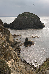 沿海地貌的石头岛悬崖地平线环境海岸天空灰色火山海洋日子多云背景图片