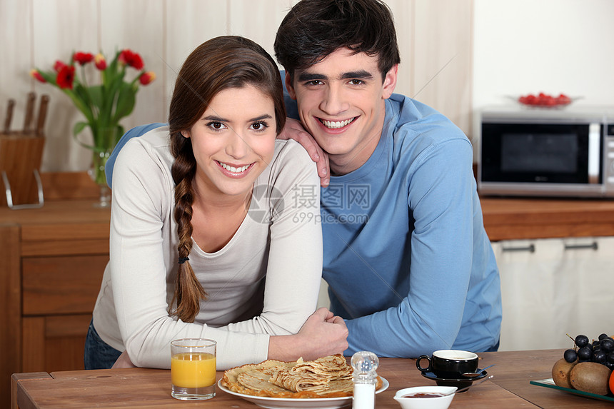 在厨房的年轻夫妇女性男朋友丈夫菜肴女孩夫妻台面果汁倾斜家务图片