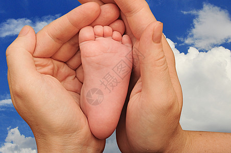 将新生婴儿的脚贴在哺乳母亲手中图片
