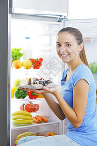 对蛋糕的渴望冰箱厨房女士饮食甜点健康饮食水果蔬菜女孩团体图片