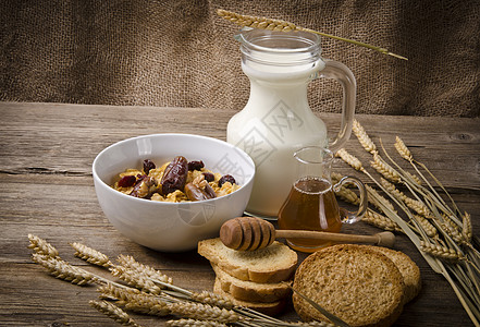 蜂蜜牛奶含低脂牛奶和面包的梅斯利蔬菜杯子农村早餐蜂蜜厨房谷物烹饪坚果饮料背景