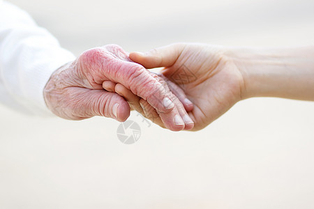 一对老人高级和青年妇女握手祖母照顾者双手女性手指团结长老女士老年白色背景
