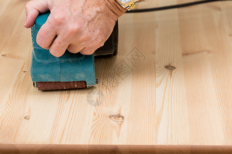 男人手在松木的皮带拖绳上机器木匠木头木工桌子工人砂带粮食砂纸工艺图片
