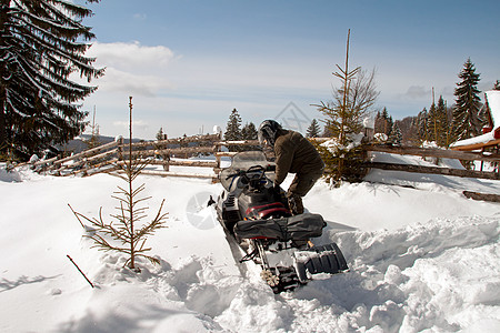 有雪车的男人车辆男性骑士雪地头盔松树寒冷运动摩托阳光图片