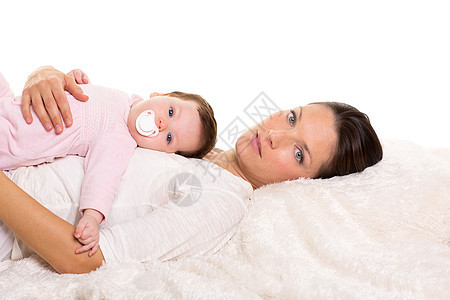 婴儿女孩和母亲在白毛皮上幸福地躺在一起女士享受女孩孩子婴儿毯子父母毛皮童年快乐图片