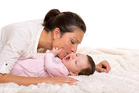 女孩和母亲的幸福快乐地一起玩耍拥抱婴儿棉被享受妻子后代工作室情感女士父母图片