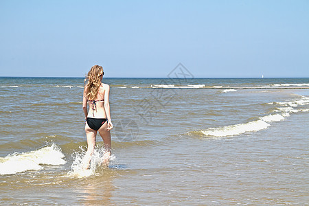 年轻女子从海洋中流过水里跑图片