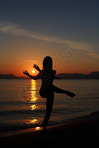 海滩上舞女的背影舞蹈家女性太阳女士舞蹈蓝色旅行天空日落女孩图片