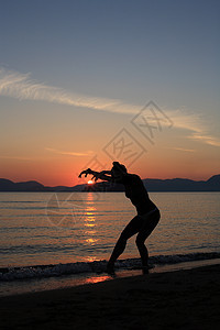海滩上舞女的背影蓝色帽子舞蹈家女士天空衣服女性旅行姿势太阳图片