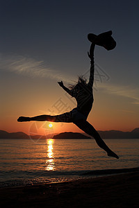 海滩上一个女孩的背影天空女士跳跃毛巾太阳舞蹈家女性舞蹈蓝色跑步图片