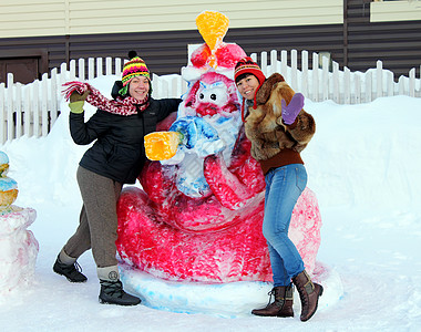 两个女孩靠近一个雪雕图片