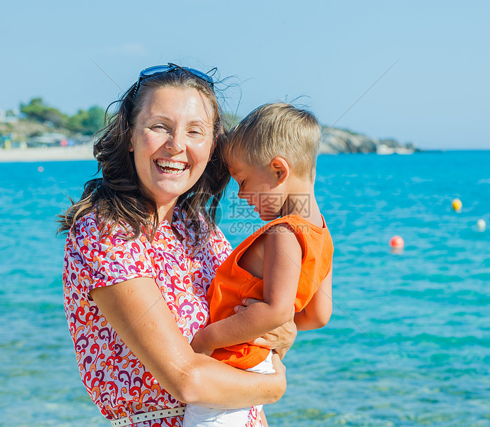 幸福的母亲和儿子在海滩上的照片青少年海洋成人季节假期天空微笑女性男人男生图片