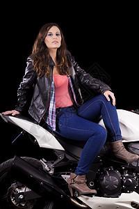 坐在一辆白色摩托车旁边的漂亮女孩头发牛仔裤速度齿轮衬衫幸福女孩自行车机器司机图片