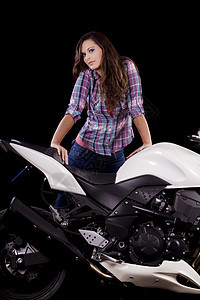 坐在一辆白色摩托车旁边的漂亮女孩衬衫女性牛仔裤车辆齿轮女孩自行车司机速度头发图片