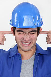 工人用手指塞住耳朵来堵住噪音图片
