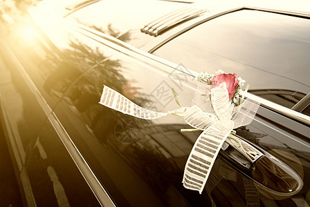 带花和丝带的黑色结婚轿车门仪式车辆婚礼夫妻婚姻花朵玫瑰运输庆典装饰图片