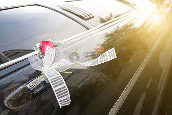 带花和丝带的黑色结婚轿车门仪式婚姻婚礼庆典奢华玫瑰夫妻运输装饰风格图片