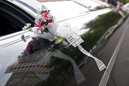 带花和丝带的黑色结婚轿车门运输花朵玫瑰夫妻风格奢华仪式庆典花束装饰图片