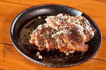 猪腿上涂着蜂蜜和大蒜食物釉面酸菜小腿美食桌子木头猪肉搪瓷平底锅图片