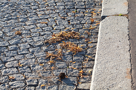 太阳照亮了铺路人的背景城市女士街道路面立方体鹅卵石岩石地面男人石头图片