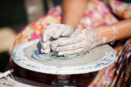 陶瓷制作在集市的陶器车轮上雕塑洞察力艺术家工匠孩子黏土围裙手指纺纱幼儿园背景