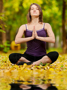 在秋季公园做瑜伽锻炼的妇女专注冥想平衡森林女孩卫生花园女性运动喜悦图片